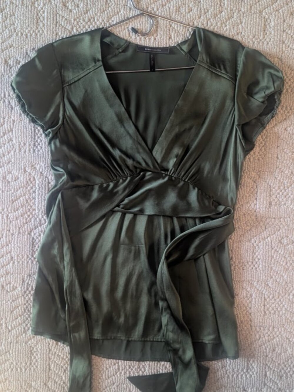 Green silk short-sleeved belted blouse.